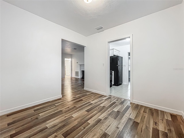 spare room with wood finished floors and baseboards