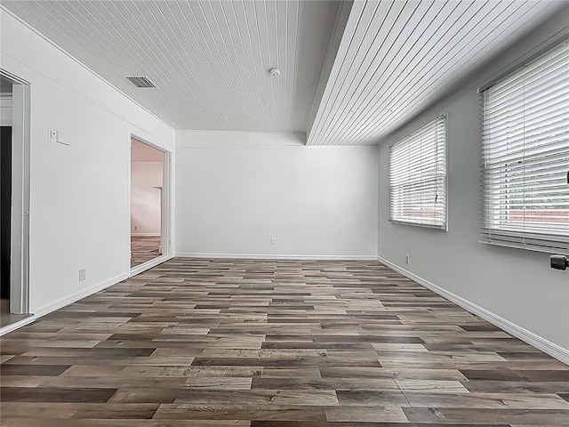 empty room featuring dark wood-type flooring and baseboards