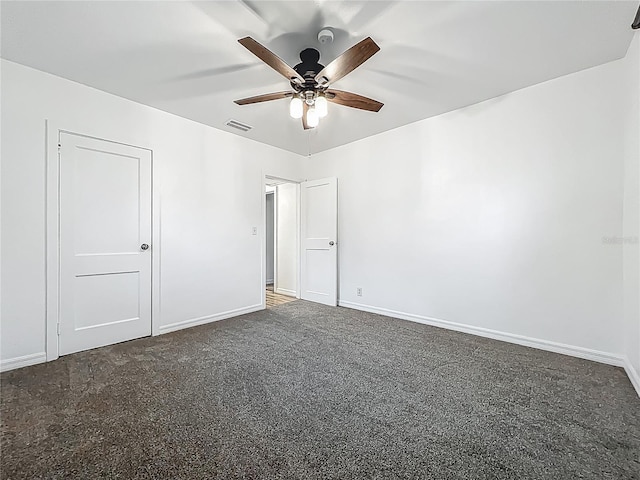 unfurnished bedroom with dark colored carpet, baseboards, and ceiling fan
