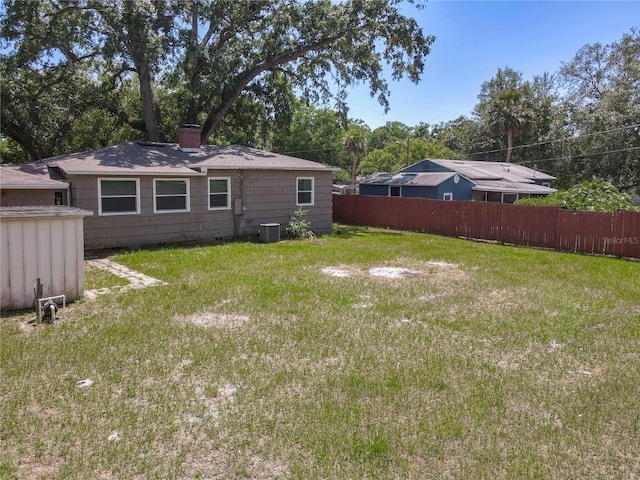 view of yard featuring fence, a shed, an outdoor structure, and central air condition unit