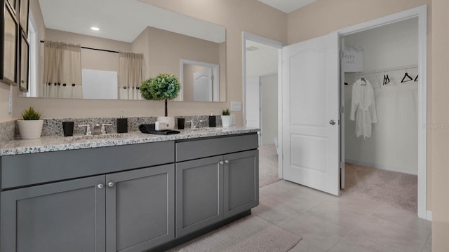 33609 Seattle Slew Dr, Sorrento, FL 32776 - full bathroom featuring double vanity, a sink, tile patterned floors, and a walk in closet