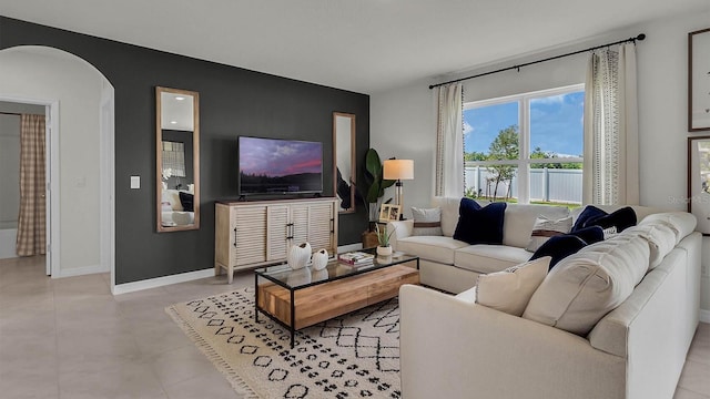33609 Seattle Slew Dr, Sorrento, FL 32776 - living room with light tile patterned floors, arched walkways, baseboards, and an accent wall