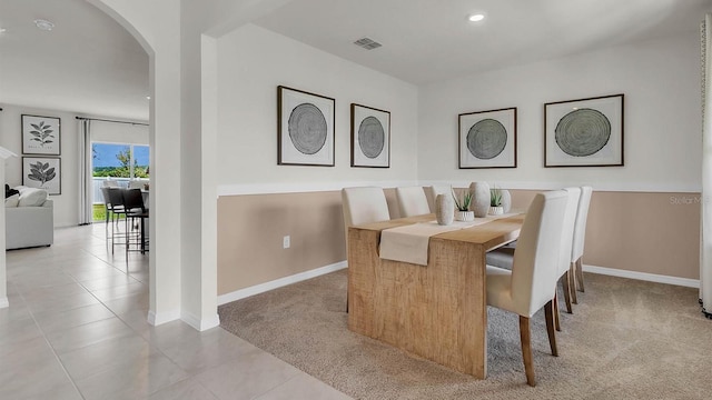 33609 Seattle Slew Dr, Sorrento, FL 32776 - carpeted dining area featuring tile patterned flooring, baseboards, visible vents, arched walkways, and recessed lighting