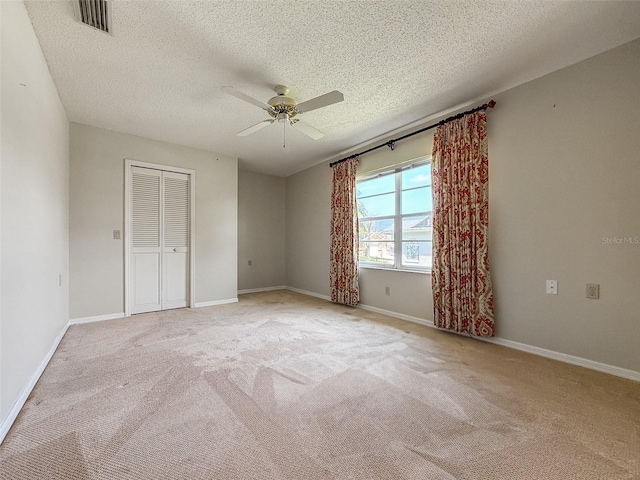 2444 Grandfather Mtn, Spring Hill, FL 34606 - unfurnished bedroom featuring carpet, a textured ceiling, a ceiling fan, a closet, and baseboards