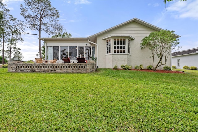 2444 Grandfather Mtn, Spring Hill, FL 34606 - back of house with a sunroom, a yard, and stucco siding