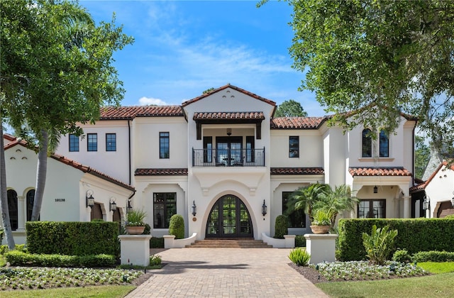 10138 Enchanted Oak Dr, Golden Oak, FL 32836 - mediterranean / spanish home featuring a balcony, french doors, stucco siding, and a tile roof