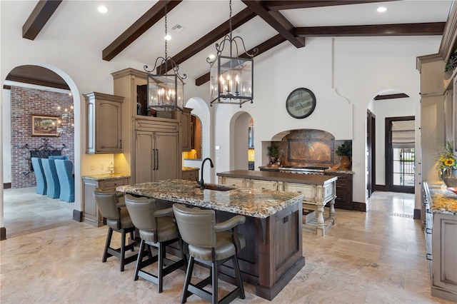 10138 Enchanted Oak Dr, Golden Oak, FL 32836 - kitchen with arched walkways, paneled refrigerator, a center island with sink, and a sink