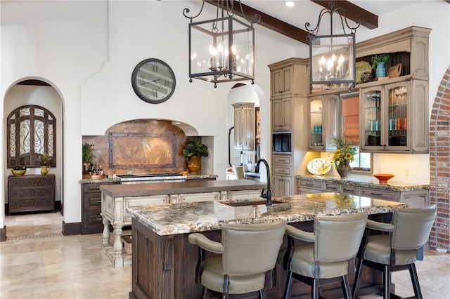 10138 Enchanted Oak Dr, Golden Oak, FL 32836 - kitchen with an inviting chandelier, an island with sink, a kitchen bar, beam ceiling, and a sink