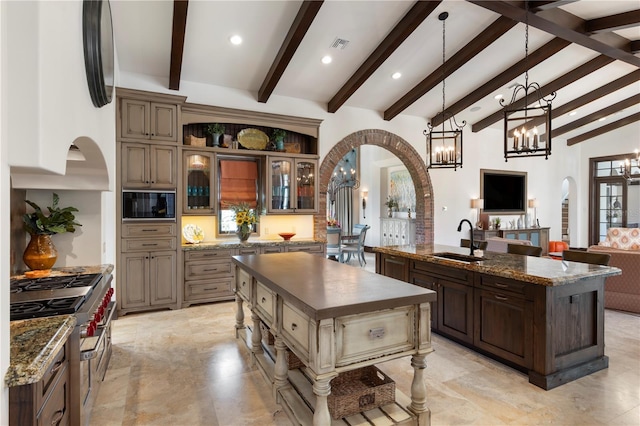 10138 Enchanted Oak Dr, Golden Oak, FL 32836 - kitchen with an island with sink, built in microwave, arched walkways, double oven range, and a sink