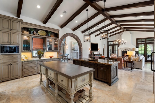 10138 Enchanted Oak Dr, Golden Oak, FL 32836 - kitchen with glass insert cabinets, arched walkways, a kitchen island, a sink, and open floor plan