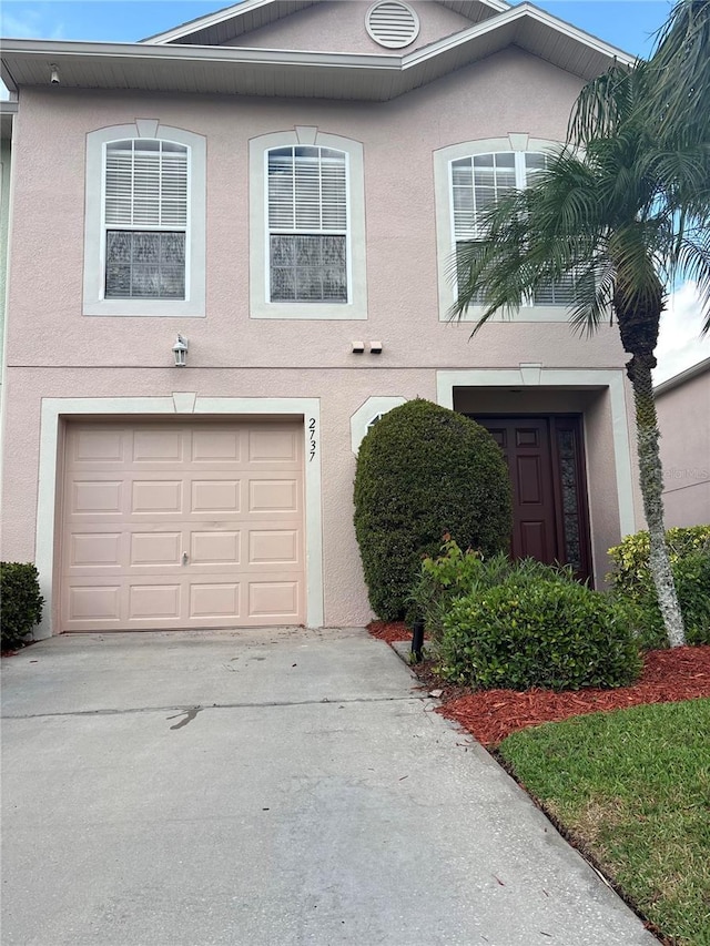 2737 Merrieweather Ln, Kissimmee, FL 34743 - traditional-style home with concrete driveway, an attached garage, and stucco siding