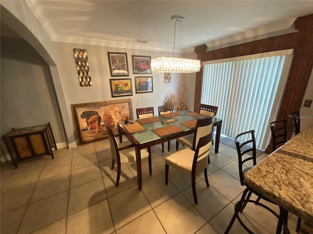 2737 Merrieweather Ln, Kissimmee, FL 34743 - dining space with crown molding, light tile patterned floors, arched walkways, a notable chandelier, and baseboards