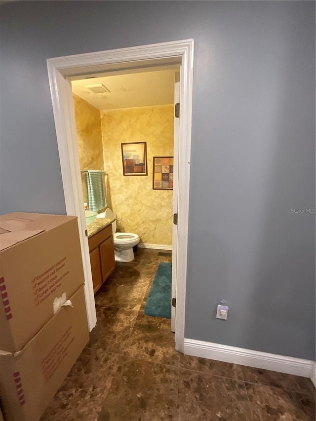 2737 Merrieweather Ln, Kissimmee, FL 34743 - bathroom with toilet, vanity, and baseboards