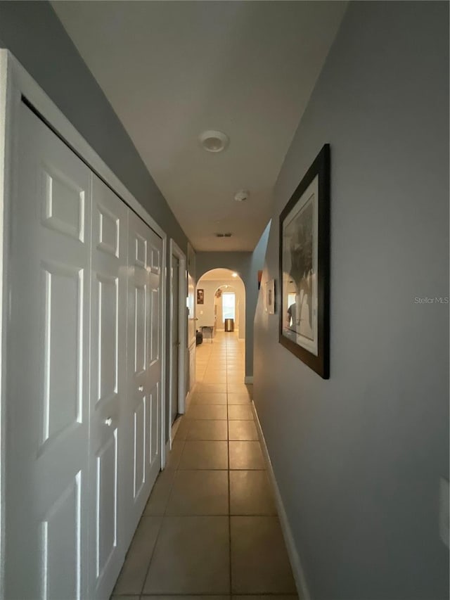 2737 Merrieweather Ln, Kissimmee, FL 34743 - corridor featuring arched walkways, light tile patterned floors, and baseboards