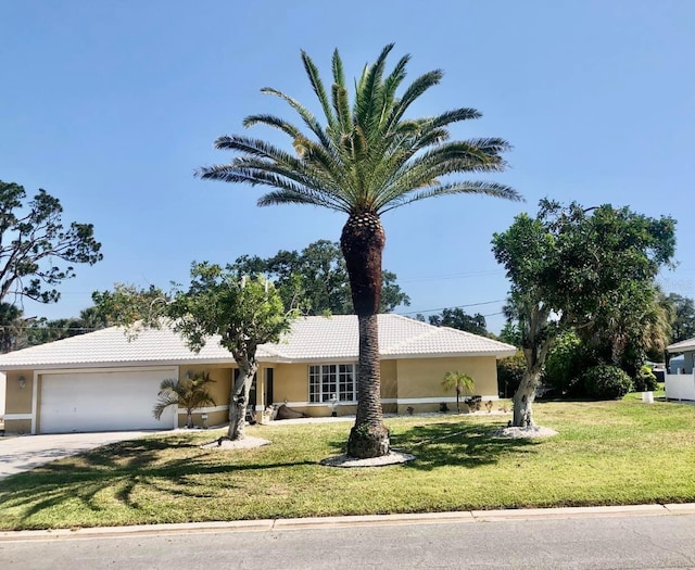 view of front of property featuring a garage, stucco siding, a front lawn, and a tile roof