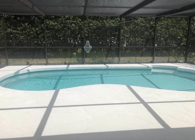 swimming pool with a lanai and a patio