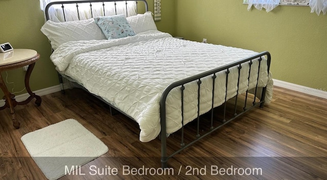 bedroom with baseboards and wood finished floors
