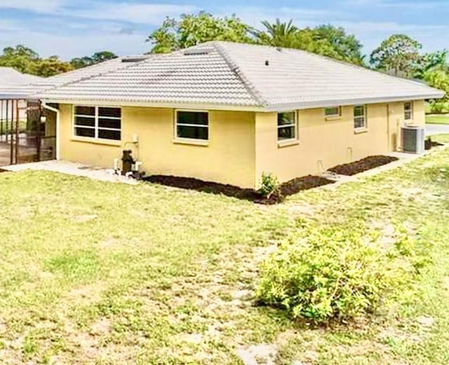 201 Chardin Dr, Nokomis, FL 34275 - rear view of property featuring stucco siding, a yard, and central air condition unit