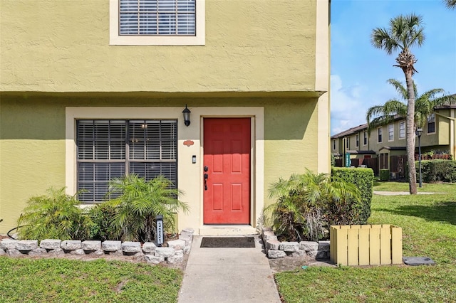 3251 Oak Lake Pl Unit 135, Winter Park, FL 32792 - property entrance with visible vents, stucco siding, and a yard