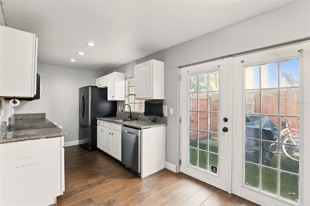 3251 Oak Lake Pl Unit 135, Winter Park, FL 32792 - kitchen with dark wood-style floors, white cabinetry, a sink, and stainless steel appliances