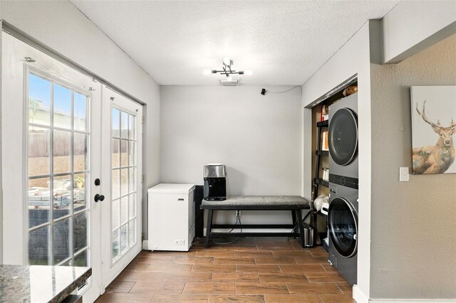 3251 Oak Lake Pl Unit 135, Winter Park, FL 32792 - laundry area featuring stacked washer / drying machine, a textured wall, a textured ceiling, laundry area, and wood tiled floor