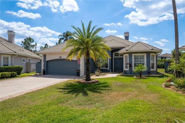 10662 Woodchase Cir, Orlando, FL 32836 - view of front facade with a tile roof, fence, an attached garage, decorative driveway, and a front lawn