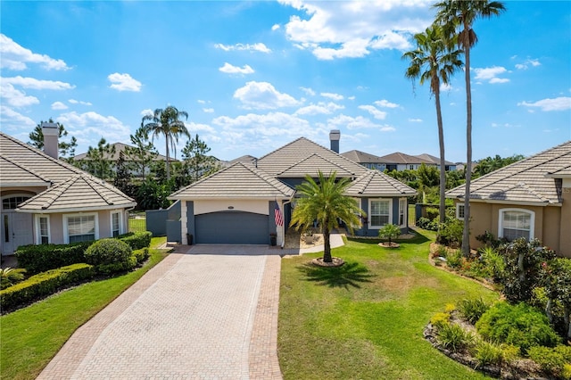 10662 Woodchase Cir, Orlando, FL 32836 - view of front of home featuring a front yard, decorative driveway, stucco siding, and an attached garage