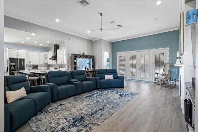 10662 Woodchase Cir, Orlando, FL 32836 - living area featuring visible vents, ornamental molding, ceiling fan, arched walkways, and light wood-type flooring