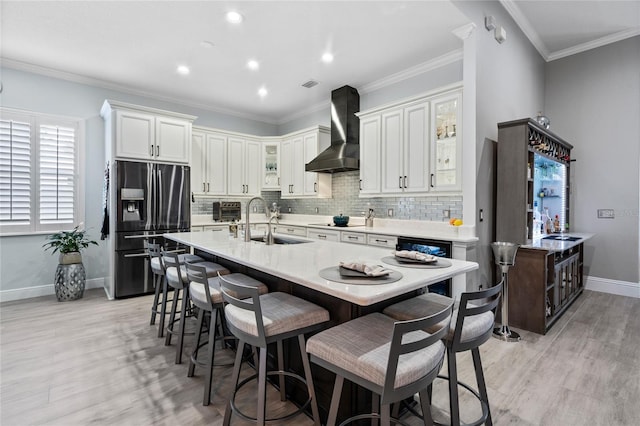 10662 Woodchase Cir, Orlando, FL 32836 - kitchen featuring decorative backsplash, light wood finished floors, a sink, stainless steel refrigerator with ice dispenser, and wall chimney range hood