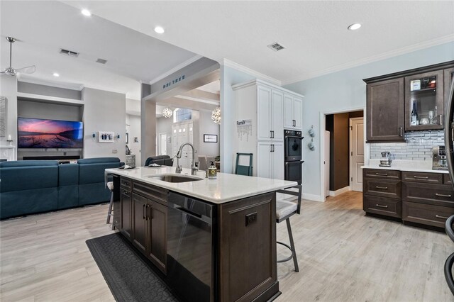 10662 Woodchase Cir, Orlando, FL 32836 - kitchen with light countertops, a sink, a kitchen breakfast bar, stainless steel dishwasher, and visible vents
