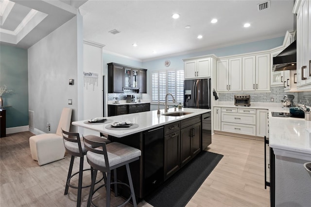 10662 Woodchase Cir, Orlando, FL 32836 - kitchen with a sink, wall chimney exhaust hood, visible vents, black appliances, and ornamental molding