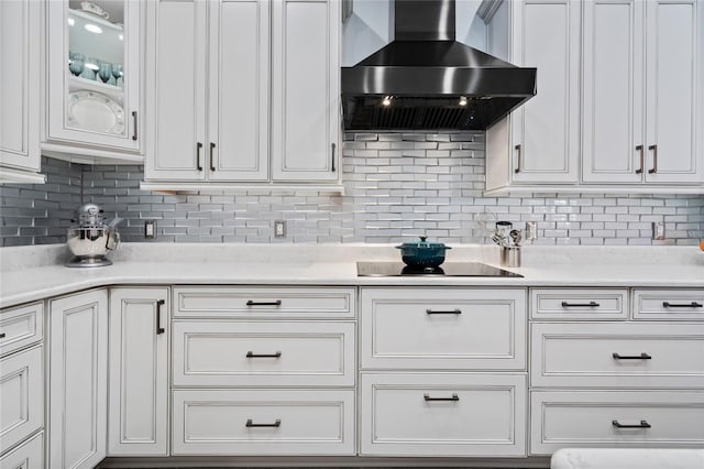 10662 Woodchase Cir, Orlando, FL 32836 - kitchen featuring white cabinetry, black electric cooktop, wall chimney exhaust hood, and tasteful backsplash