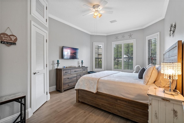 10662 Woodchase Cir, Orlando, FL 32836 - bedroom featuring a ceiling fan, light wood finished floors, baseboards, visible vents, and ornamental molding