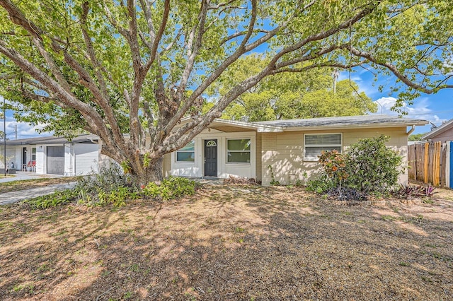 ranch-style home featuring a garage and fence