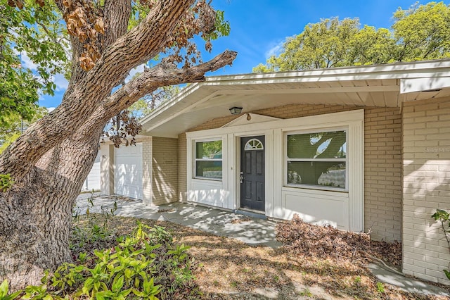 entrance to property featuring brick siding