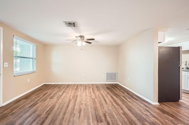 empty room with visible vents, baseboards, ceiling fan, and wood finished floors