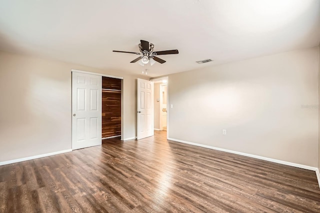 unfurnished bedroom featuring ceiling fan, baseboards, wood finished floors, visible vents, and a closet