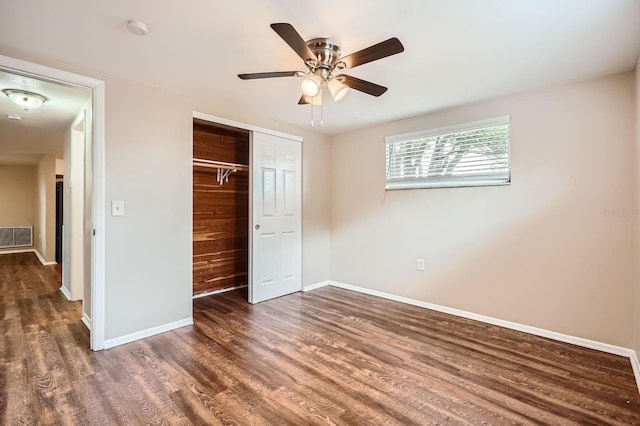 unfurnished bedroom featuring ceiling fan, baseboards, wood finished floors, visible vents, and a closet
