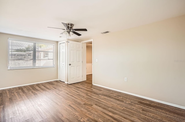 unfurnished bedroom with baseboards, a ceiling fan, wood finished floors, and visible vents