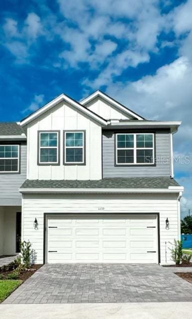 1533 Heritage Pl, Oviedo, FL 32765 - view of front of home with a shingled roof, a garage, and decorative driveway