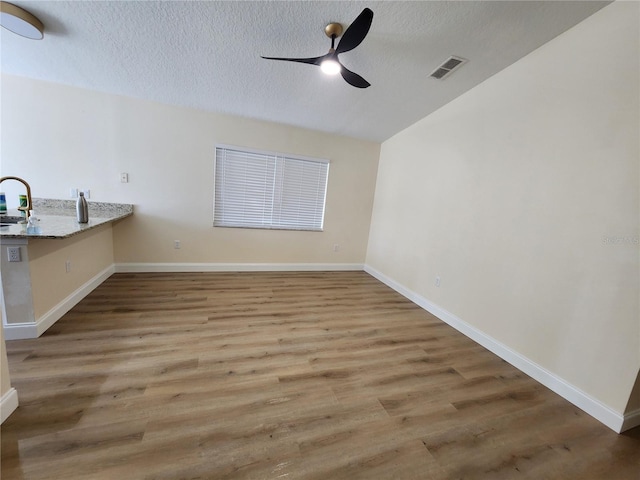 101 Dovetail Ct, Apopka, FL 32703 - unfurnished dining area with a ceiling fan, a textured ceiling, a sink, wood finished floors, and baseboards