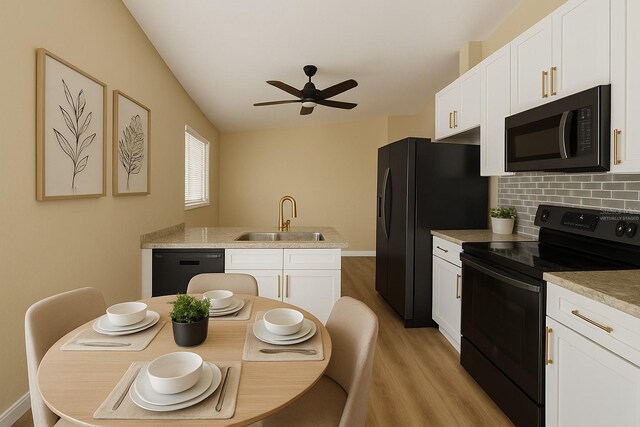 101 Dovetail Ct, Apopka, FL 32703 - kitchen with black appliances, a sink, light wood-style floors, a ceiling fan, and white cabinetry