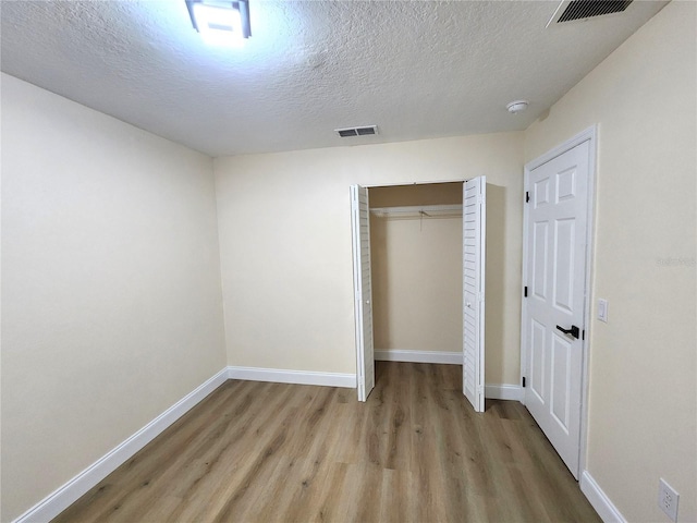 101 Dovetail Ct, Apopka, FL 32703 - unfurnished bedroom with wood finished floors, baseboards, a textured ceiling, and a closet