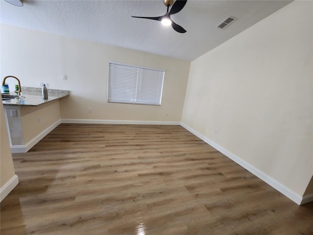 101 Dovetail Ct, Apopka, FL 32703 - unfurnished dining area featuring ceiling fan, wood finished floors, baseboards, a sink, and a textured ceiling
