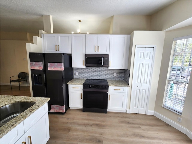 101 Dovetail Ct, Apopka, FL 32703 - kitchen featuring black appliances, backsplash, white cabinetry, and light stone countertops