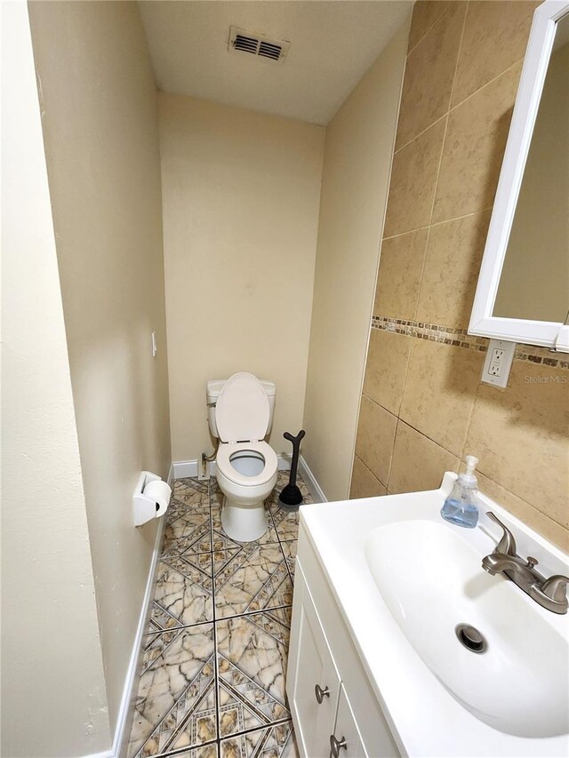 101 Dovetail Ct, Apopka, FL 32703 - bathroom featuring vanity, toilet, baseboards, and tile walls