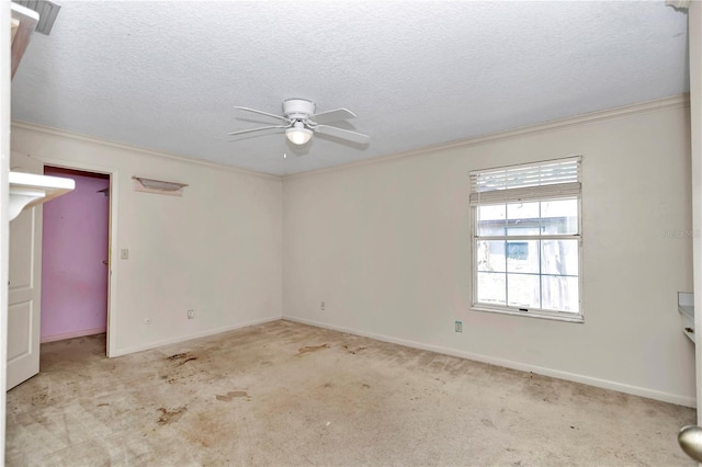 empty room with crown molding, baseboards, a textured ceiling, carpet floors, and ceiling fan