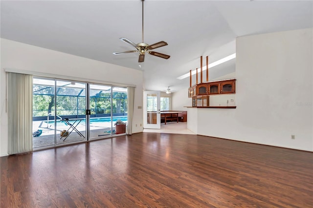 unfurnished living room with a ceiling fan, a sunroom, lofted ceiling, and wood finished floors
