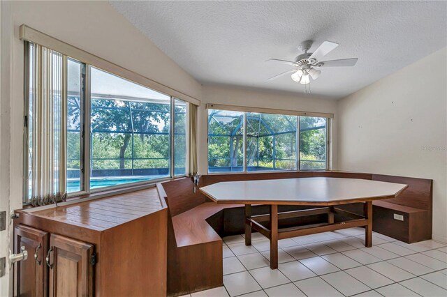 dining room featuring a textured ceiling, ceiling fan, breakfast area, and light tile patterned floors