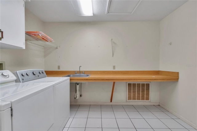 laundry room with independent washer and dryer, a sink, cabinet space, and visible vents